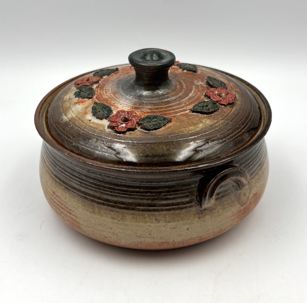 Covered dish with toasty brown glaze and orange accents