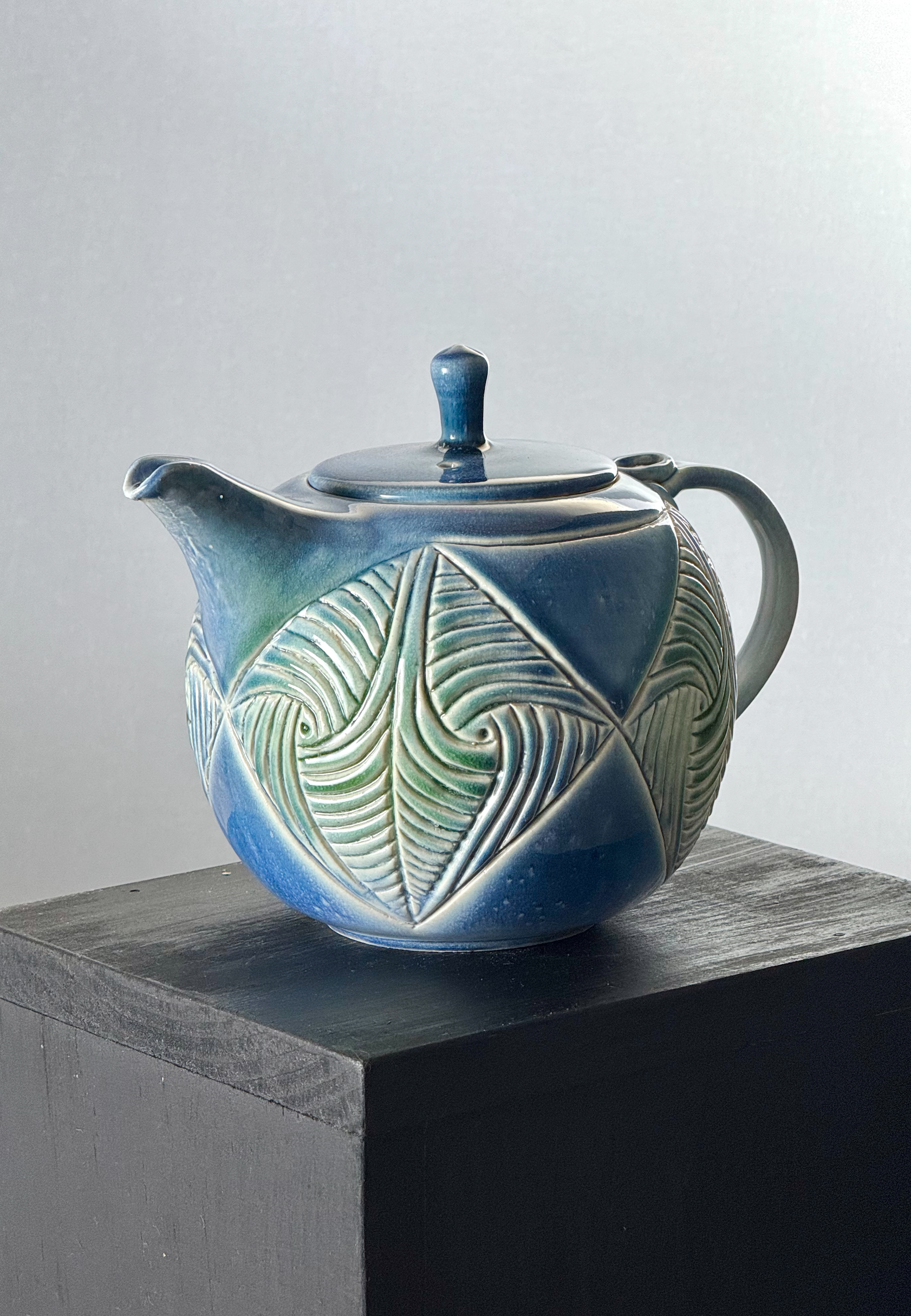 Carved teapot with light green and blue glaze