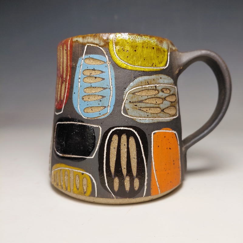Carved Mug with Carving over colorful dots of color